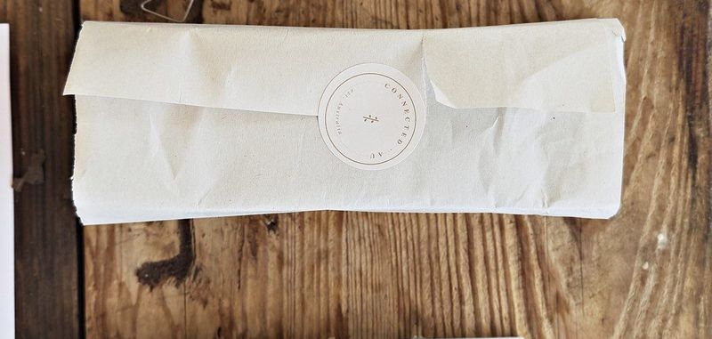 A box wrapped in tissue and sealed by hand, ready to post