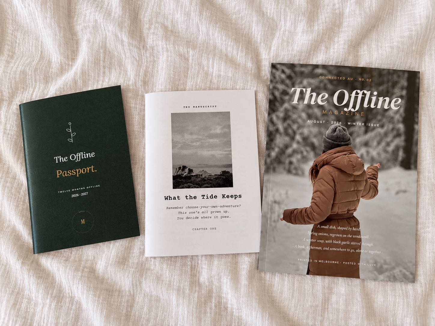 The Offline Passport, The Manuscript and The Offline Magazine laid out on linen